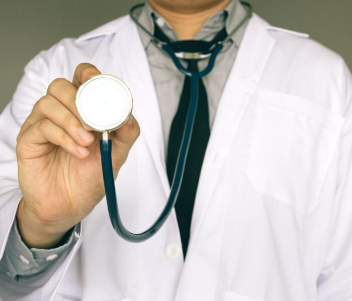 Male doctor holding stethoscope.
